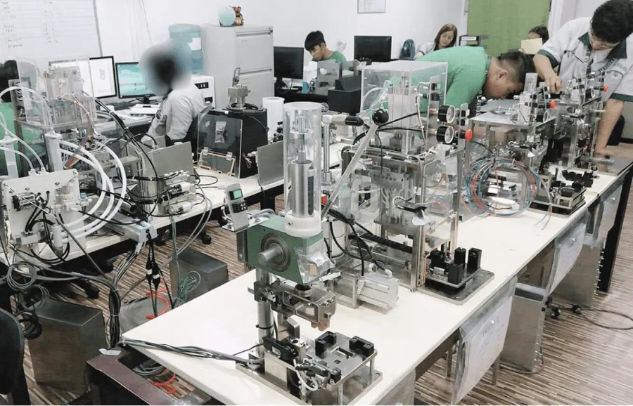 ATOM engineers assembling custom table-top automation machines in the workshop