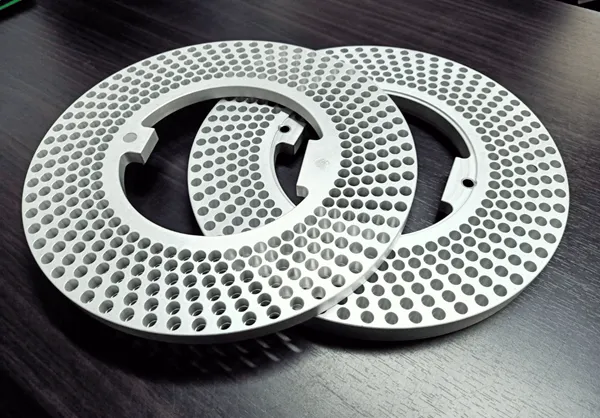 Two precision-fabricated perforated fill rings used as custom production tooling