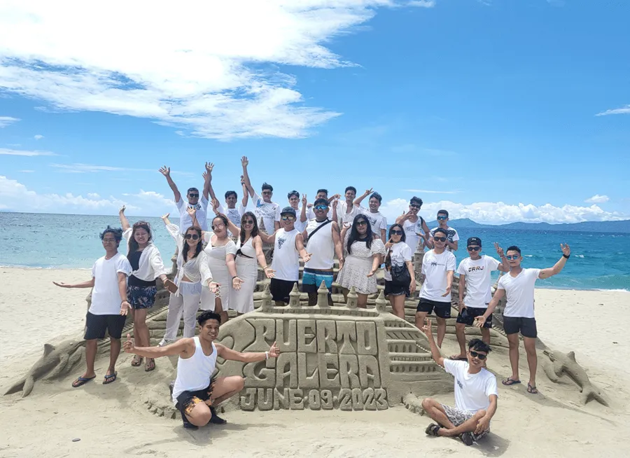 ATOM team members posing together at a company beach outing in Puerto Galera
